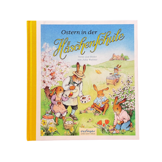 Ein buntes Kinderbuch mit vielen Hasen aus der Hasenschule auf einer Wiese.