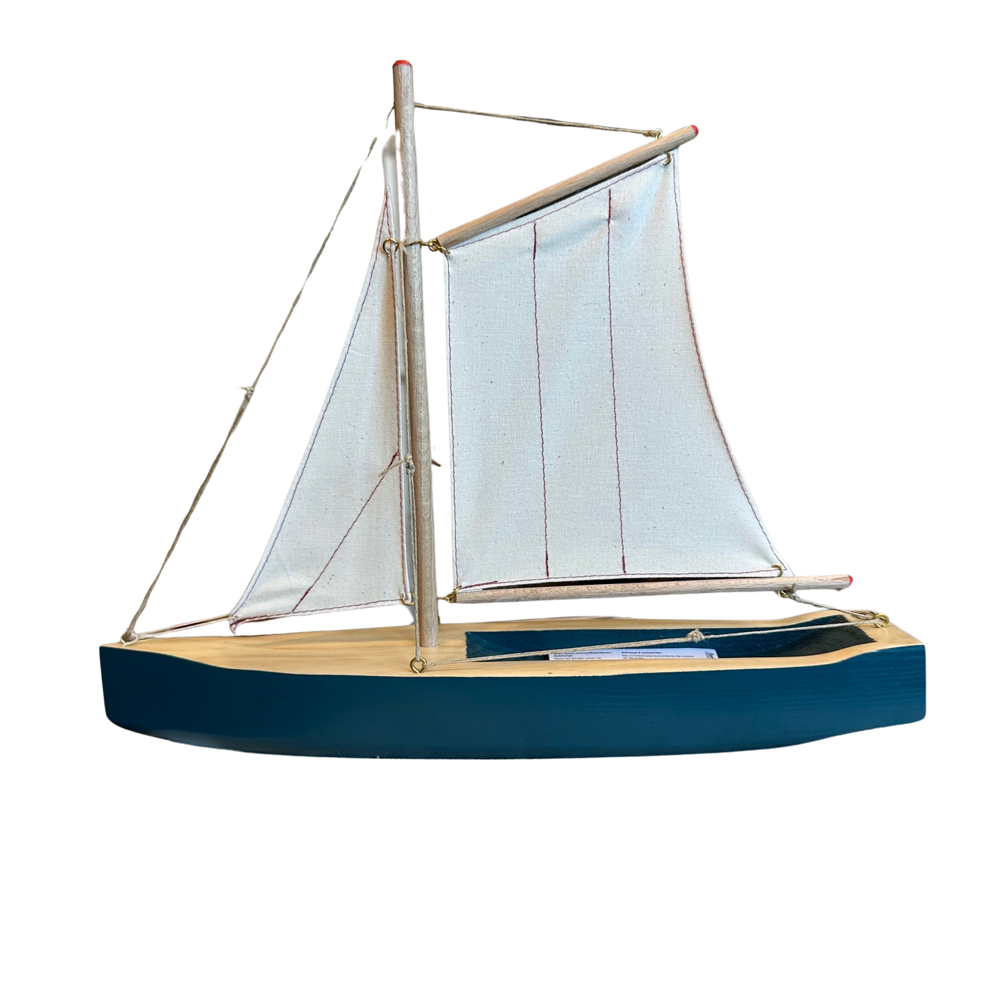 Segelschiff aus Holz in Blau mit hellen Segeln.