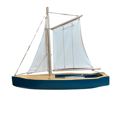 Segelschiff aus Holz in Blau mit hellen Segeln.